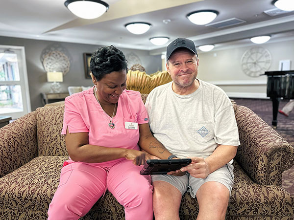 Nurse helping patient use tablet